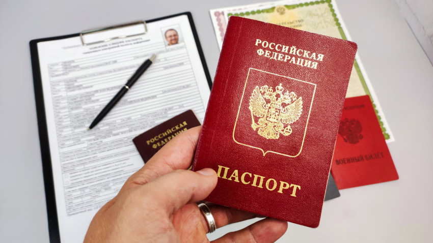 Загранпаспорт РФ в руке и анкета на выдачу паспорта