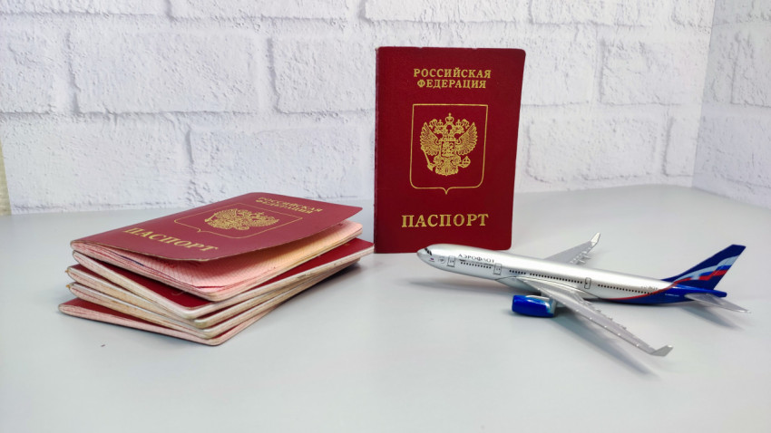 Загранпаспорт РФ и модель самолета на столе