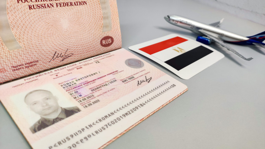 Загранпаспорт России и флаг Египта на фоне модели самолета
