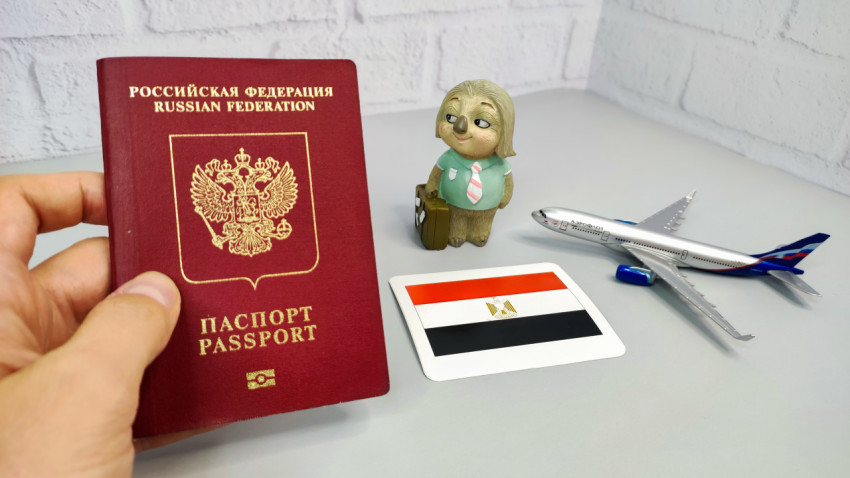 Российский загранпаспорт, флаг Египта и модель самолета на столе
