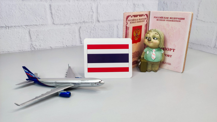 Российский заграничный паспорт, карта с флагом Таиланда и модель самолета