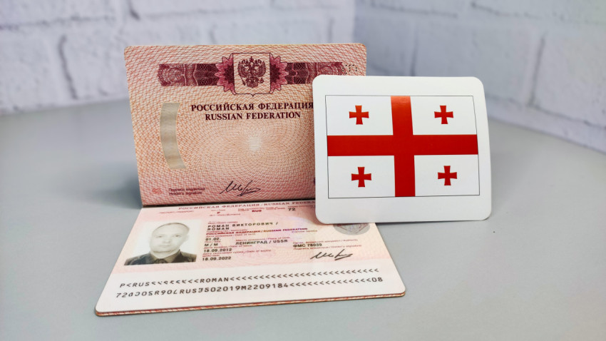 Российский загранпаспорт и карта с флагом Грузии на столе