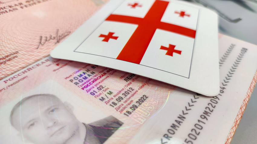 Загранпаспорт России и карта с флагом Грузии
