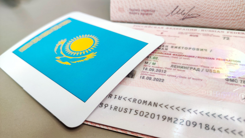 Загранпаспорт РФ и карта с флагом Казахстана крупным планом