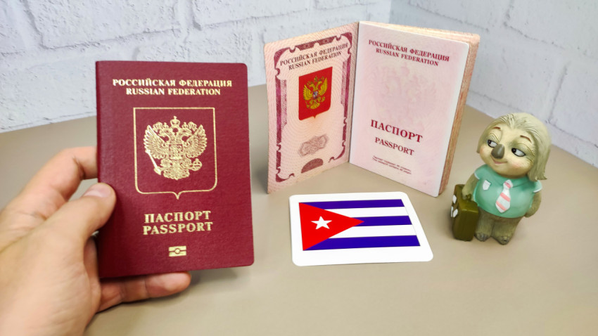 Загранпаспорт РФ в руке, флаг Кубы и открытые документы