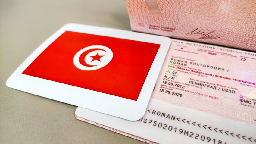 Загранпаспорт РФ и флаг Туниса крупным планом