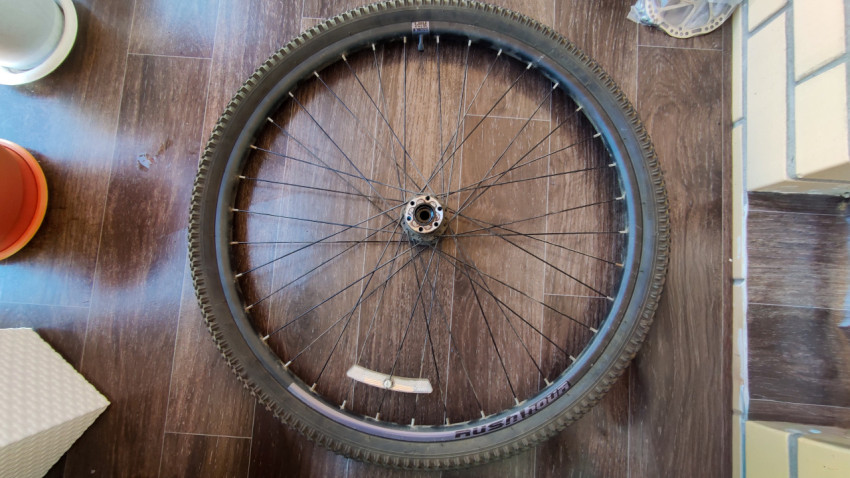 Велосипедное колесо без тормозного диска на деревянном полу