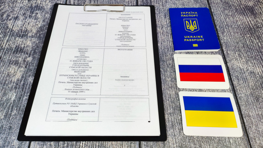Перевод украинского паспорта и оригинал биометрического паспорта на фоне флагов