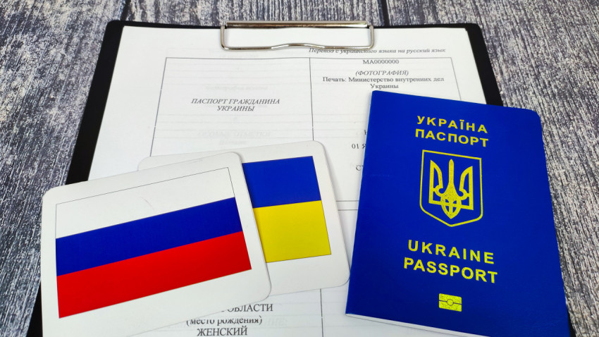 Паспорт гражданина Украины и флаги России и Украины на фоне документа