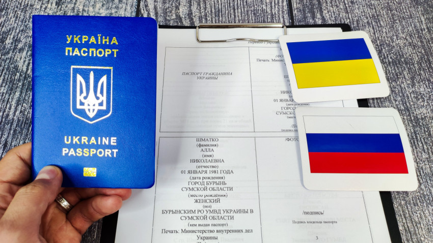 Украинский паспорт и документ с личными данными на фоне флагов Украины и России