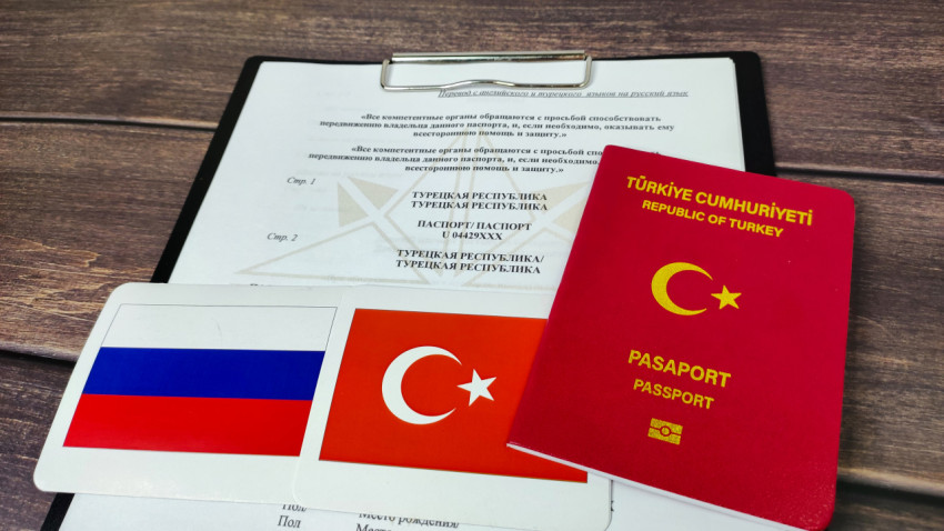Турецкий паспорт на фоне перевода документа и флагов России и Турции