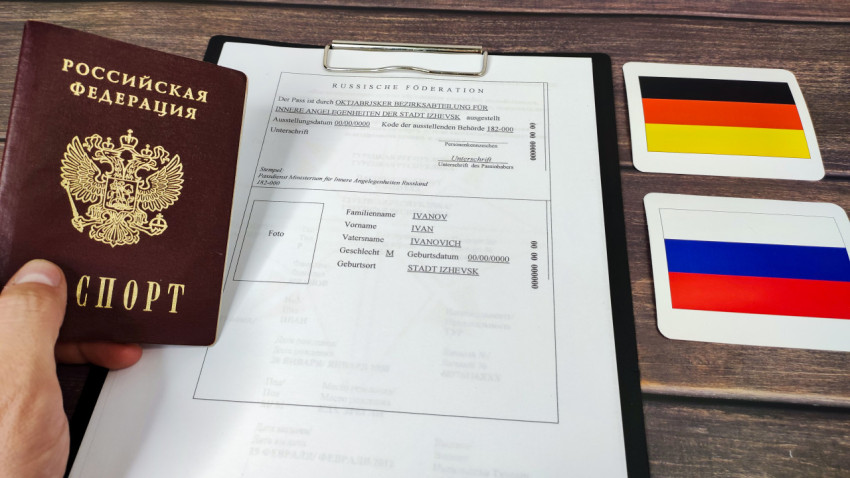 Российский паспорт в руке и перевод документа на немецкий язык