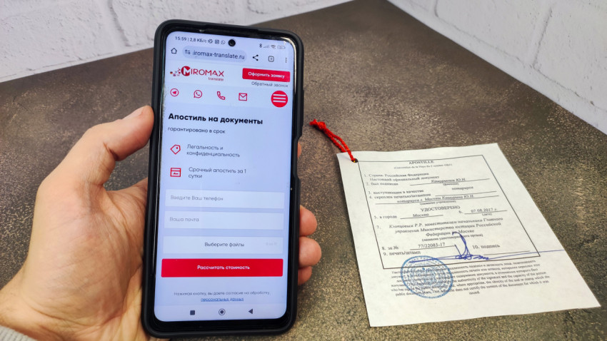 Апостиль Российской Федерации рядом со смартфоном с сайтом переводческой компании