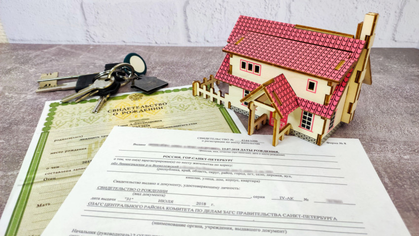 Макет дома с ключами и документами о регистрации
