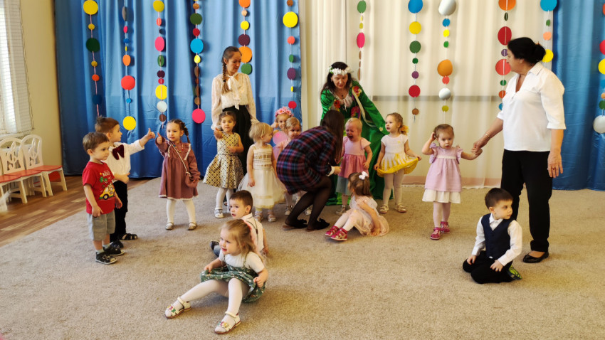 Маленькие дети и педагоги на празднике в детском саду