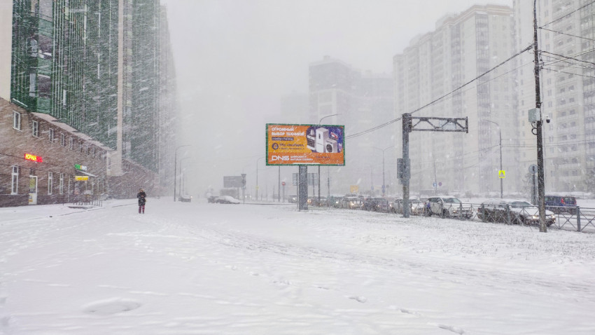 Сильный снегопад на улице современного жилого района