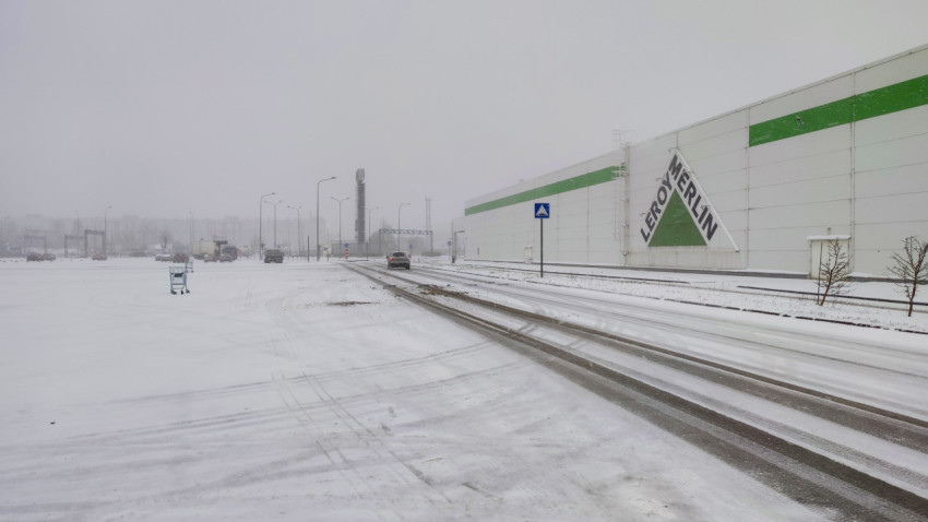 Заснеженная дорога у фасада гипермаркета Leroy Merlin