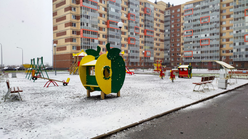 Детская площадка во дворе жилого комплекса в первый снег