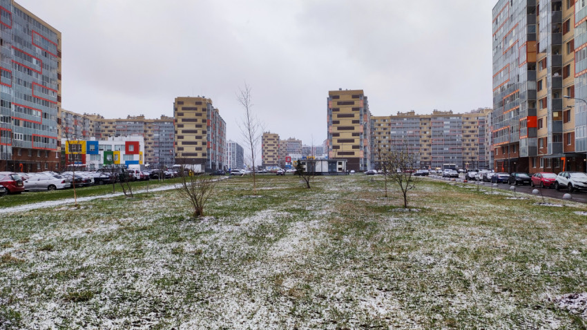 Озеленённая придомовая территория жилого района с тающим снегом