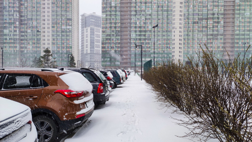 Ряд припаркованных автомобилей на фоне многоэтажных домов