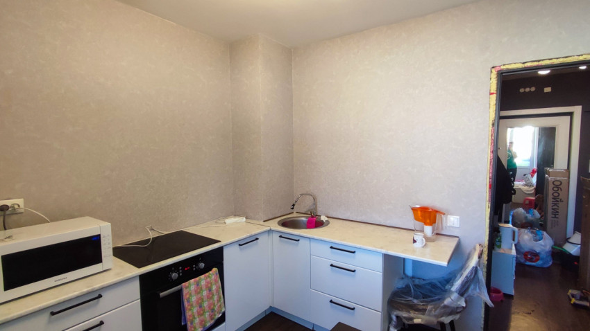 Угловая кухня с новыми обоями и входом в комнату