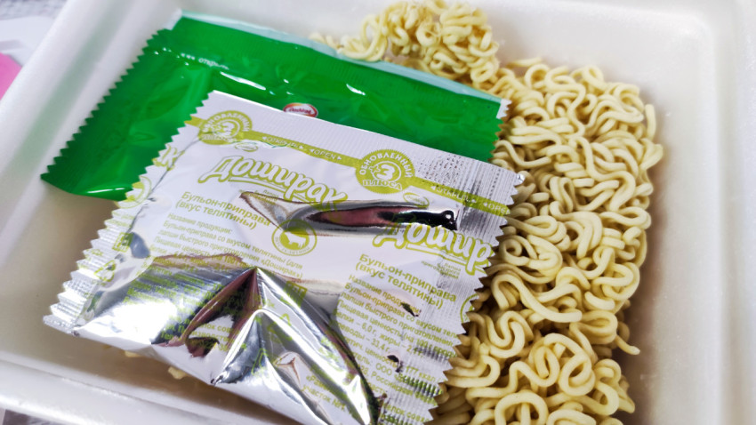 Пакеты приправ «Доширак» и брикет лапши в открытом контейнере