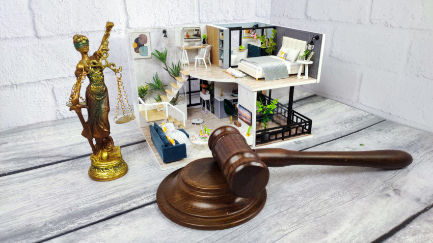 Статуэтка Фемиды и макет интерьера рядом с судейским молотком