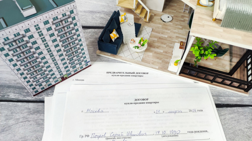 Договоры купли-продажи квартиры рядом с макетом здания и интерьера