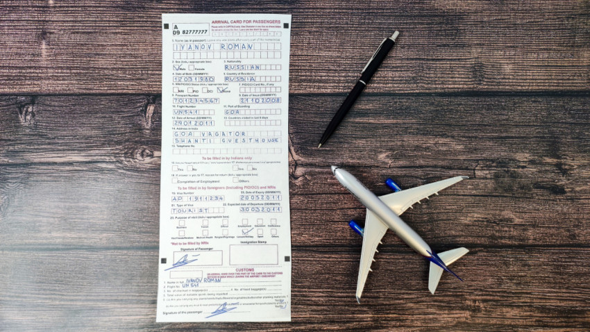 Заполненная миграционная карта на деревянной поверхности