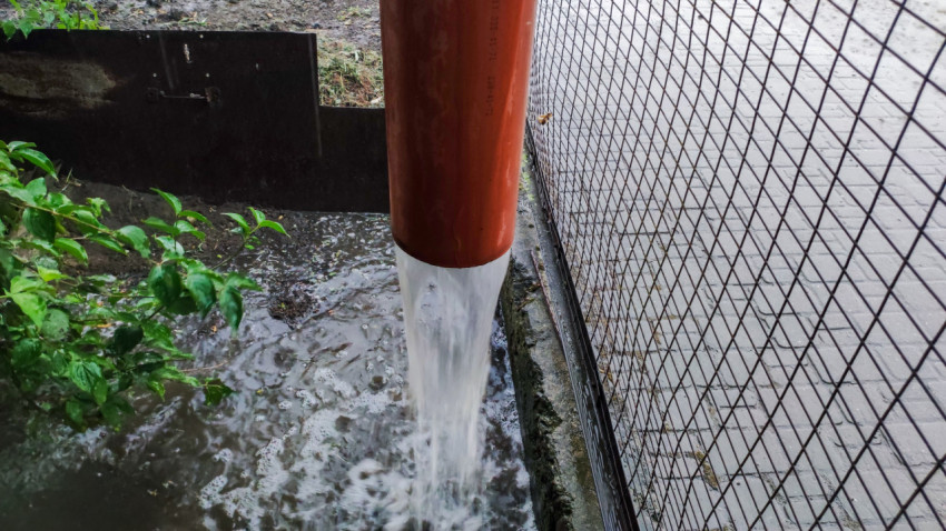 Поток дождевой воды из водосточной трубы