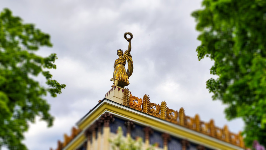 Скульптура девушки с венком на карнизе павильона «Украина»