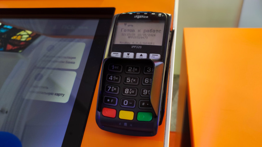 Платёжный терминал Ingenico рядом с сенсорным экраном