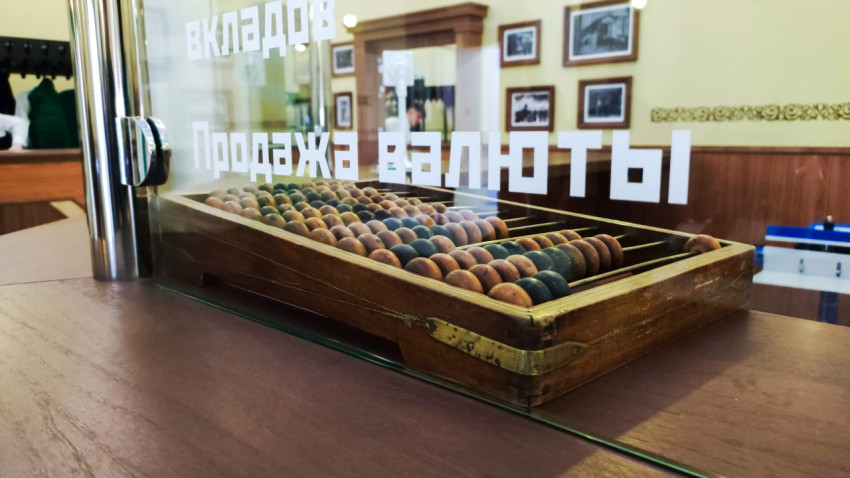 Старинные счёты за стеклянной перегородкой исторической кассы