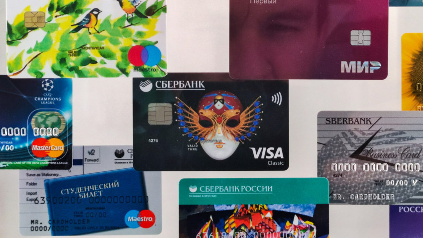 Фрагмент стенда Сбера с картами Visa, Maestro и Мир