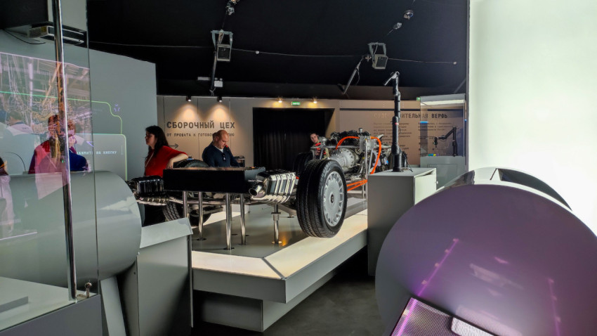 Экспозиция с автомобильным шасси и посетителями в зоне «Сборочный цех»