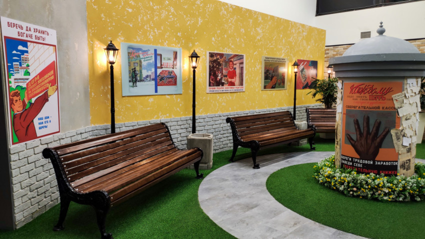 Интерьер зоны «Прошлое» с советскими плакатами и уличной мебелью