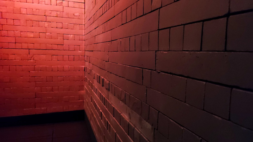 Кирпичная кладка подземного коридора павильона «АТОМ» с красной подсветкой
