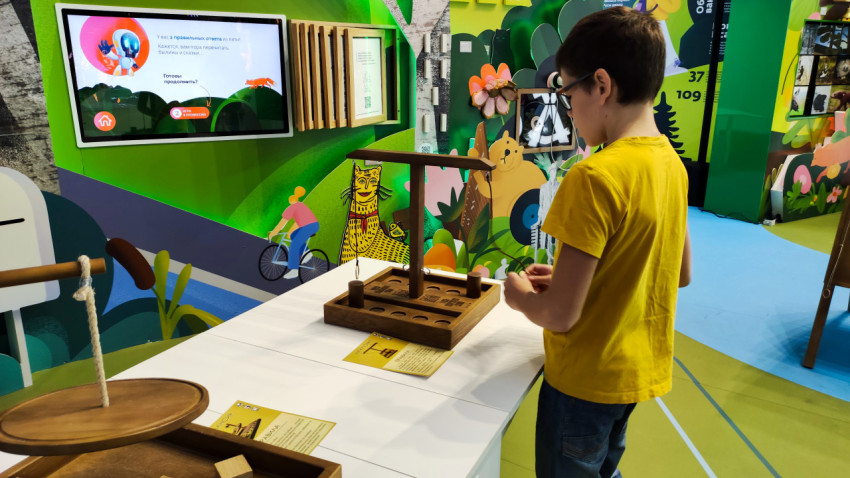 Ребёнок у интерактивного обучающего экспоната на выставке