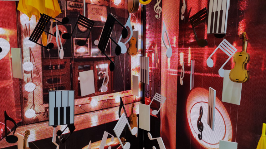 Инсталляция с музыкальными символами и инструментами на светодиодном фоне
