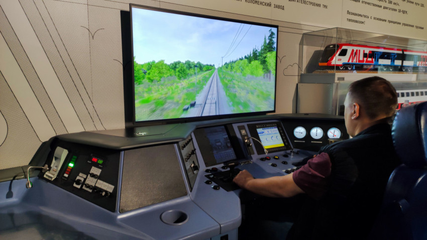 Тренажёр машиниста с экраном и пультом управления в павильоне Е