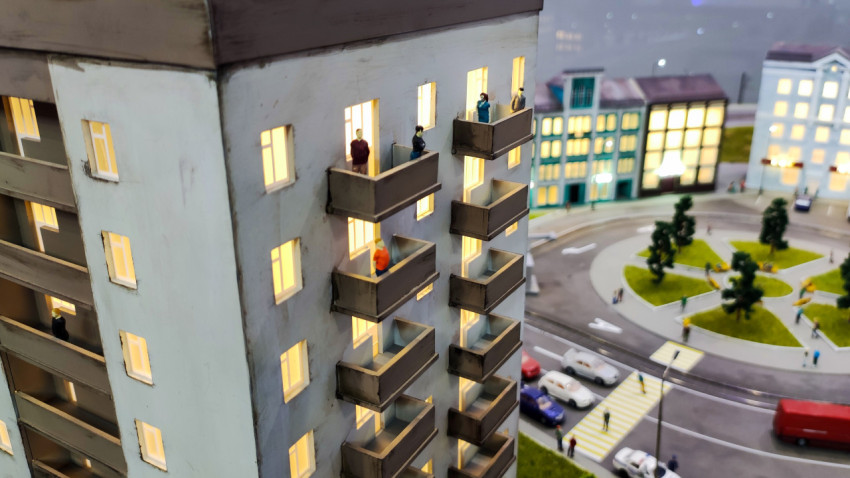 Фасад макета многоэтажного дома с балконами и подсветкой окон