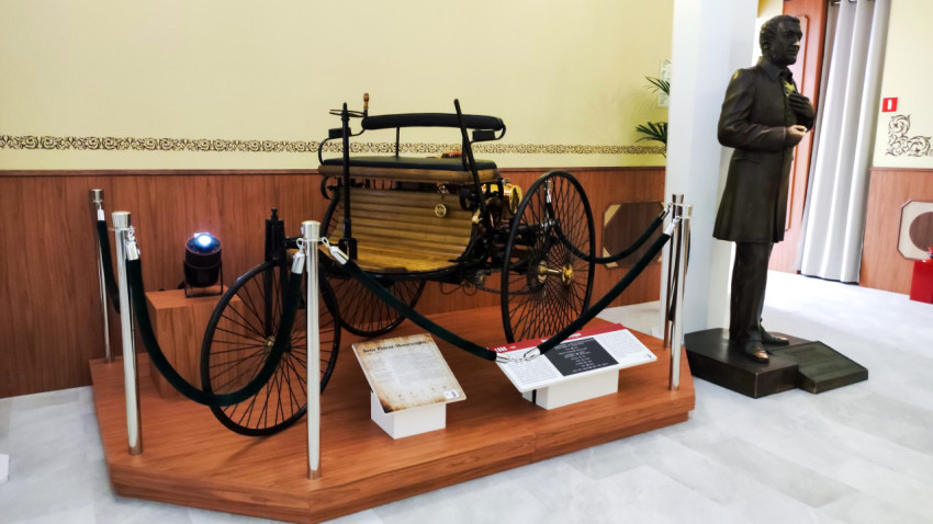 Экспонат Benz Patent-Motorwagen и статуя из исторической зоны
