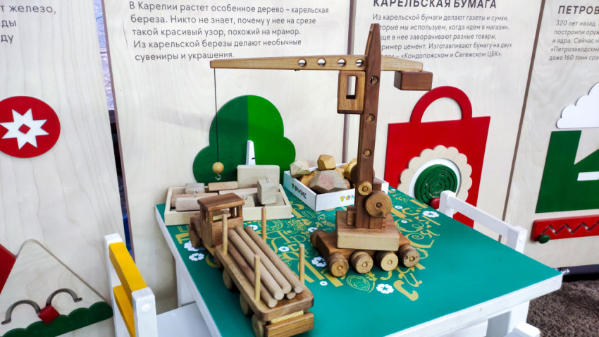 Деревянные игрушки и макеты лесной техники на выставочном столе