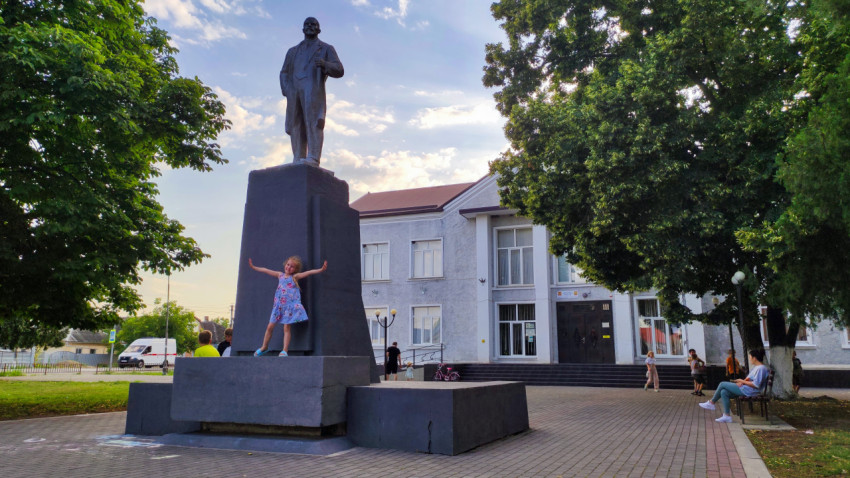 Девочка позирует у памятника Ленину на площади