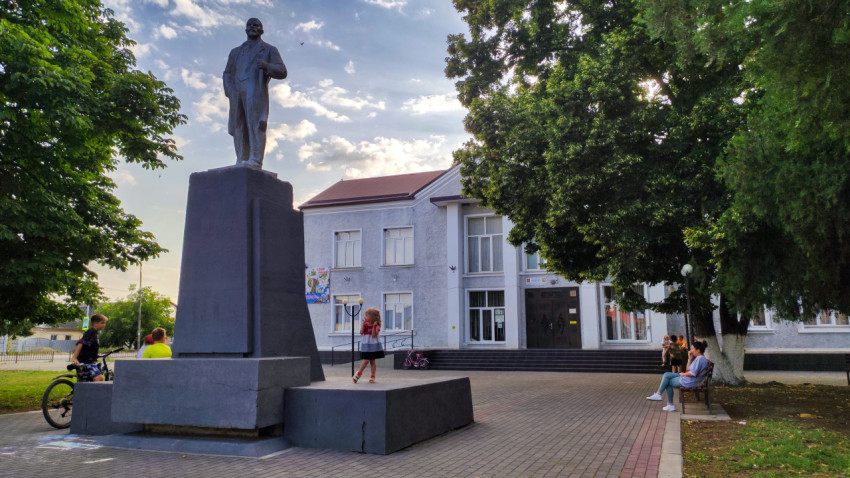 Памятник Ленину у общественного здания и аллеи