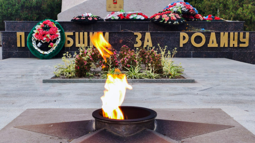 Пламя вечного огня и надпись «Павшим за Родину» на гранитной стене мемориала в Прохладном