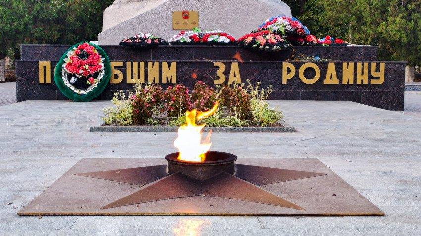 Пламя Вечного огня на звезде перед мемориальной стеной в Прохладном