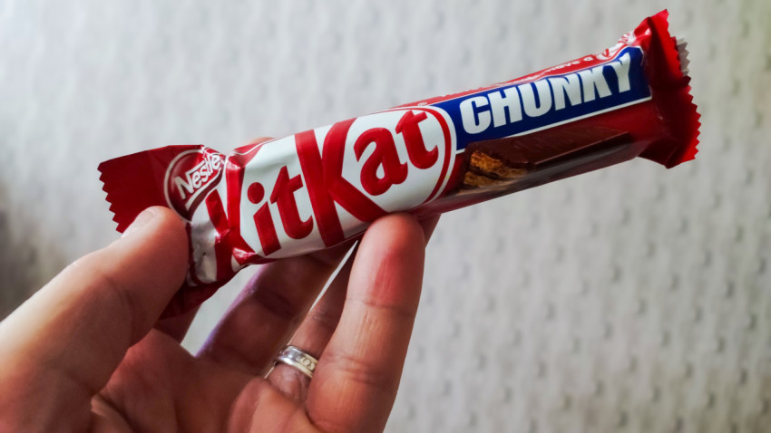 Батончик Nestlé KitKat Chunky в руке на светлом фоне
