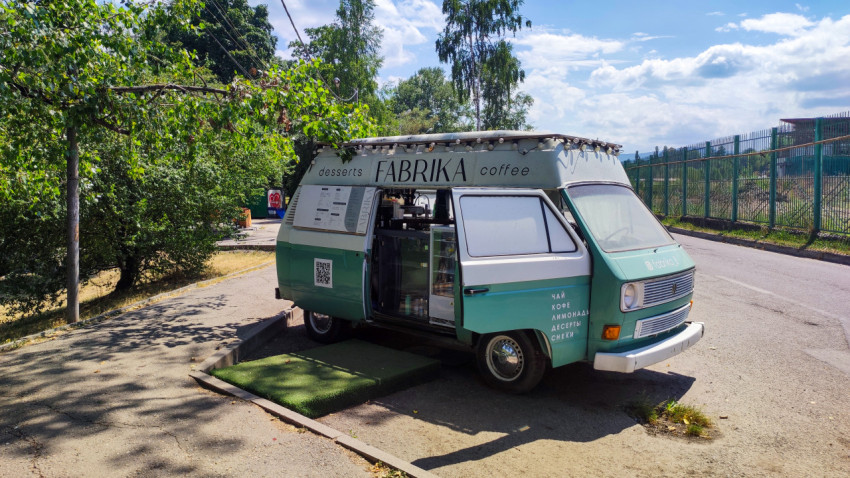 Фудтрак FABRIKA coffee с меню и открытой витриной у дорожного бордюра