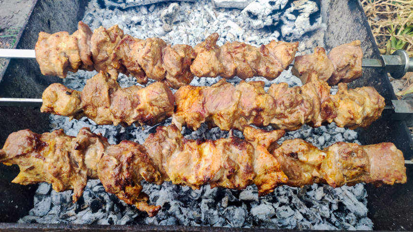 Шашлык на шампурах над серыми углями